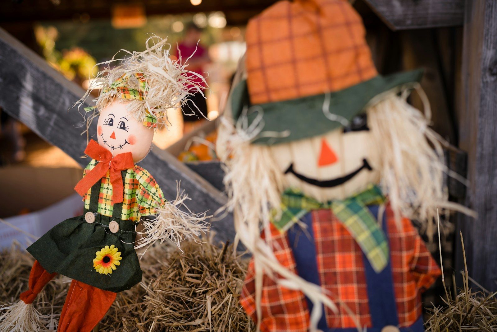 a couple of scarecrows sitting on top of a pile of hay